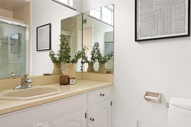 bathroom featuring vanity, toilet, and a stall shower