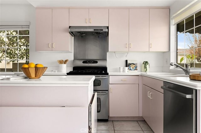 kitchen featuring under cabinet range hood, a sink, stainless steel appliances, light countertops, and light tile patterned floors