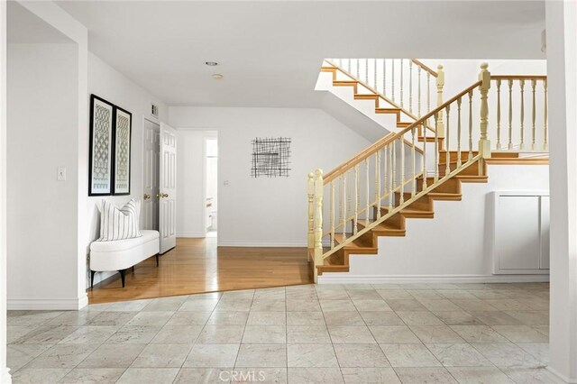 foyer with stairs and baseboards