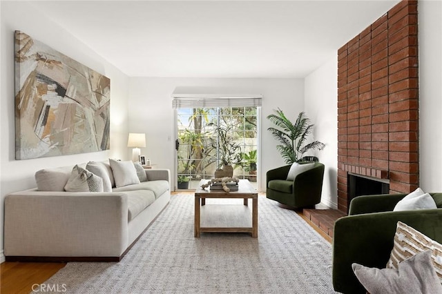 living area featuring a brick fireplace and wood finished floors