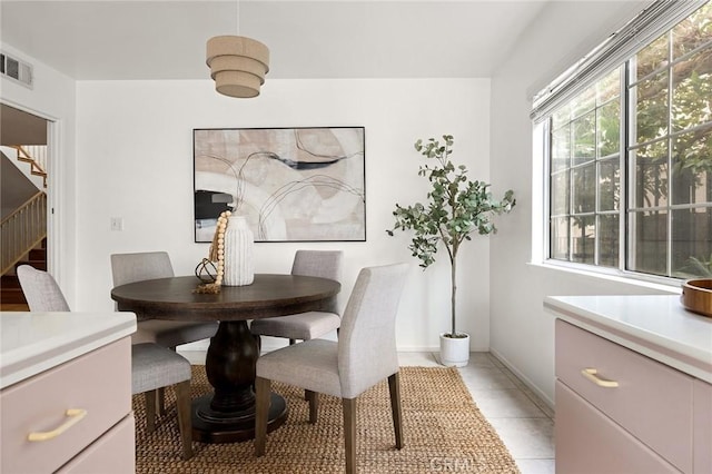 dining area with light tile patterned floors, stairway, baseboards, and visible vents