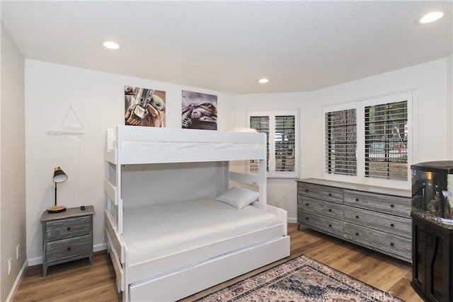 bedroom with light wood-style floors, baseboards, and recessed lighting