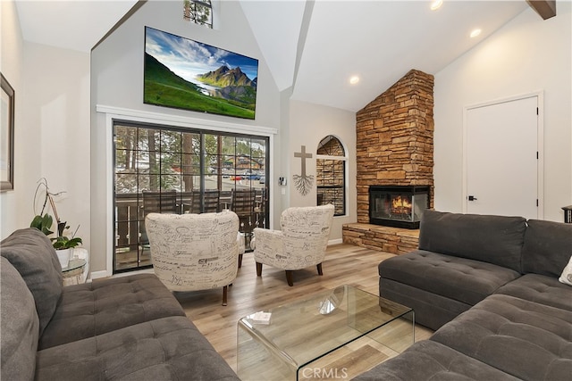 living room with high vaulted ceiling, light wood-type flooring, a fireplace, and recessed lighting