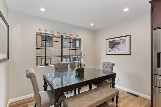 dining space featuring light wood finished floors, baseboards, visible vents, and recessed lighting