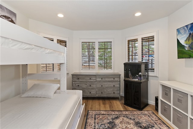 bedroom with multiple windows, wood finished floors, and recessed lighting