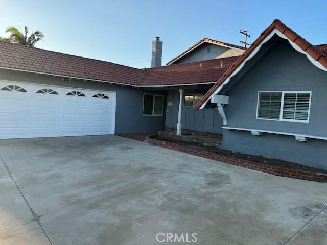 single story home with a garage, driveway, and stucco siding