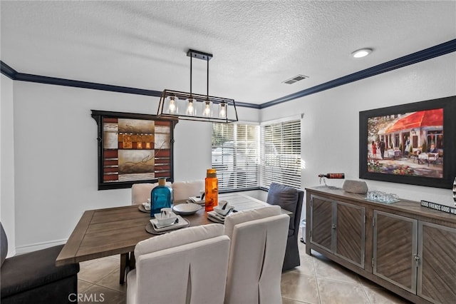 dining area with baseboards, visible vents, light tile patterned flooring, ornamental molding, and a textured ceiling