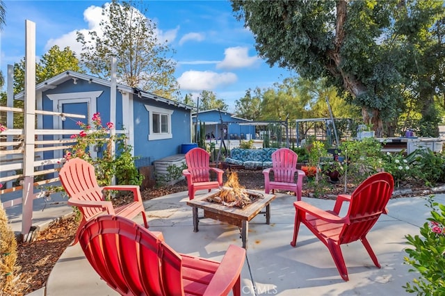 view of patio featuring an outbuilding, fence, and an outdoor fire pit