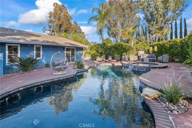 pool with a patio and an in ground hot tub