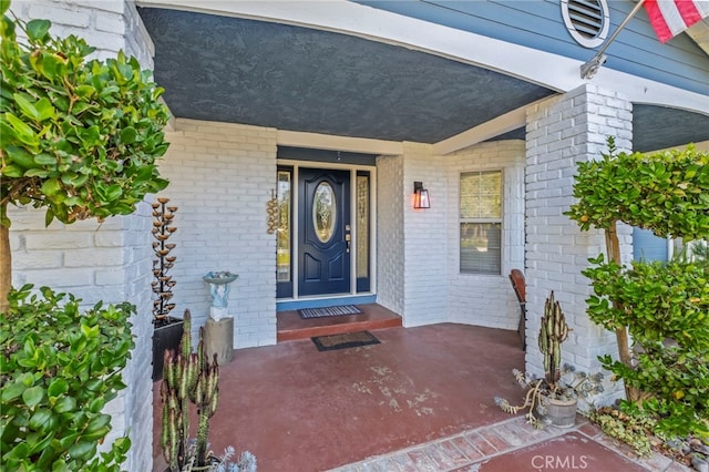 property entrance featuring brick siding