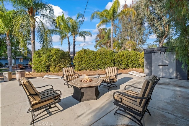 view of patio / terrace featuring a fire pit, a storage shed, and an outdoor structure