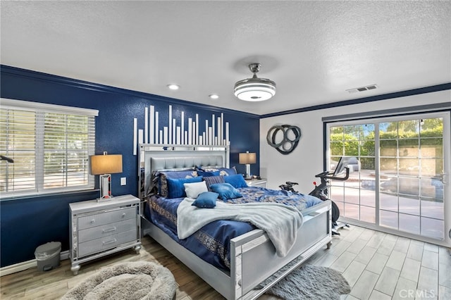 bedroom with wood finished floors, visible vents, access to exterior, a textured ceiling, and crown molding