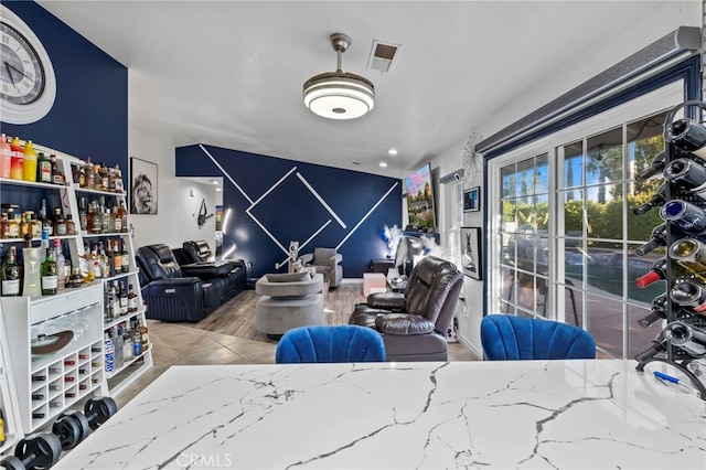 living area with visible vents and an accent wall