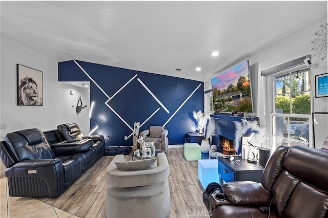 living area featuring an accent wall, recessed lighting, visible vents, and wood tiled floor