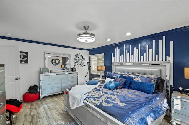 bedroom featuring wood finished floors and crown molding