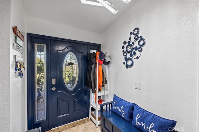 tiled foyer with a textured wall