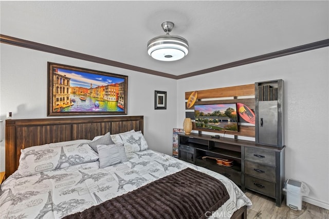 bedroom featuring light wood-type flooring and crown molding