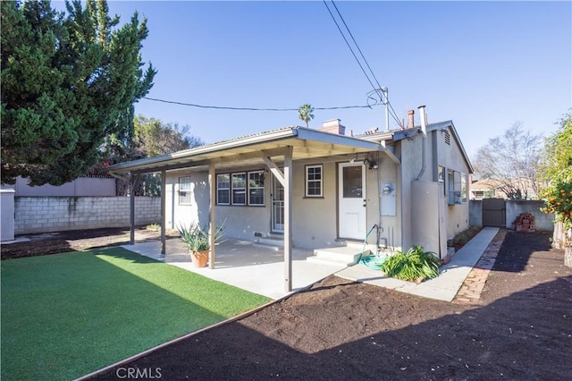 view of front of home featuring a front yard, a fenced backyard, entry steps, and stucco siding