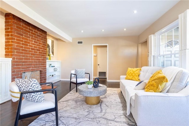 living area with baseboards, visible vents, wood finished floors, a brick fireplace, and recessed lighting