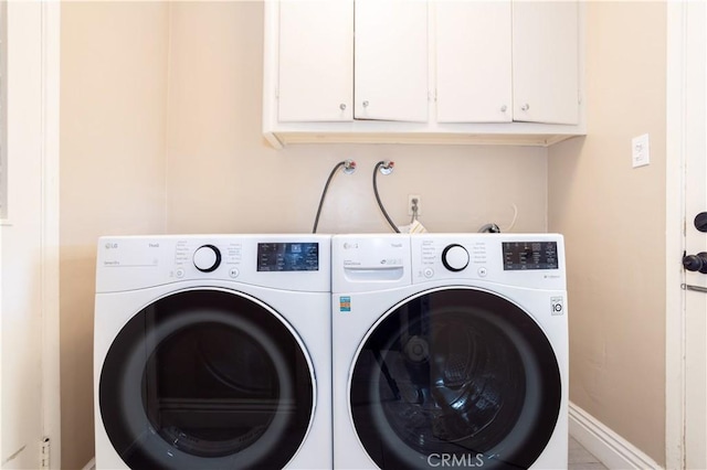 clothes washing area with cabinet space, independent washer and dryer, and baseboards