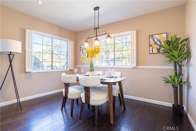 dining space with an inviting chandelier, baseboards, and wood finished floors