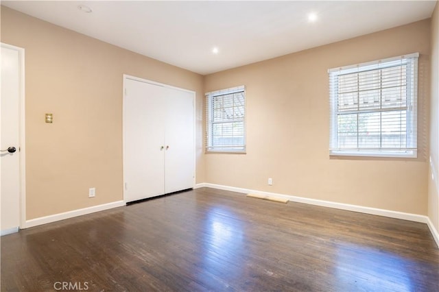 unfurnished bedroom with baseboards, wood finished floors, and recessed lighting