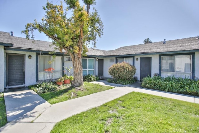 single story home with stucco siding and a front lawn