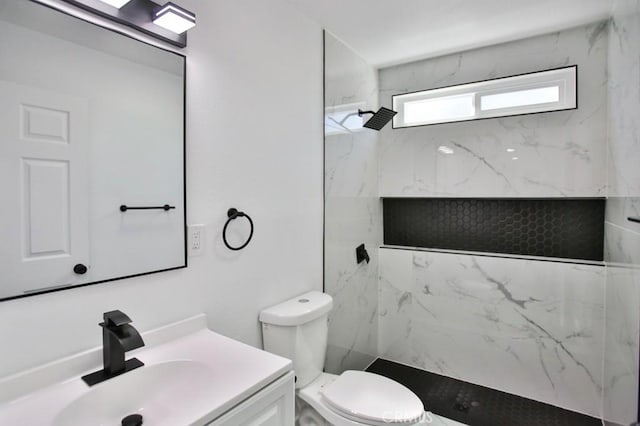 bathroom featuring a marble finish shower, toilet, and vanity