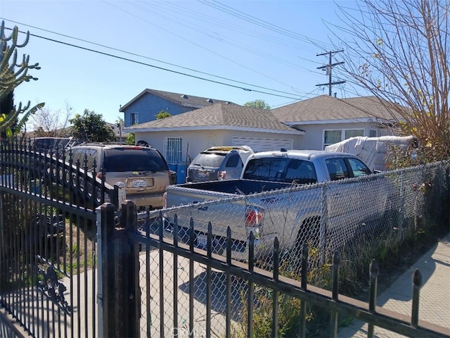 view of front of property with a shingled roof, fence private yard, and stucco siding