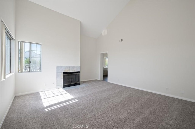 unfurnished living room featuring carpet, a fireplace, and baseboards