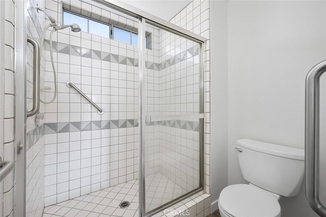 bathroom featuring toilet and a shower stall