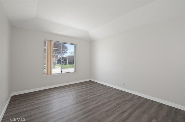 empty room with dark wood finished floors and baseboards