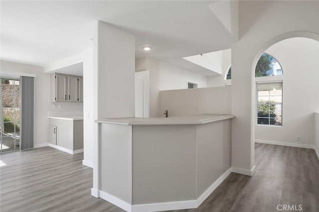 interior space with baseboards, light countertops, and wood finished floors