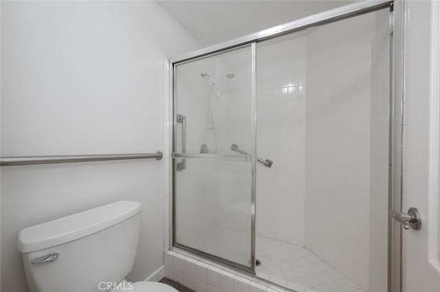 bathroom featuring toilet and a stall shower