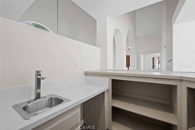 interior space with lofted ceiling, light countertops, and a sink