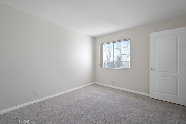 spare room with carpet flooring and baseboards