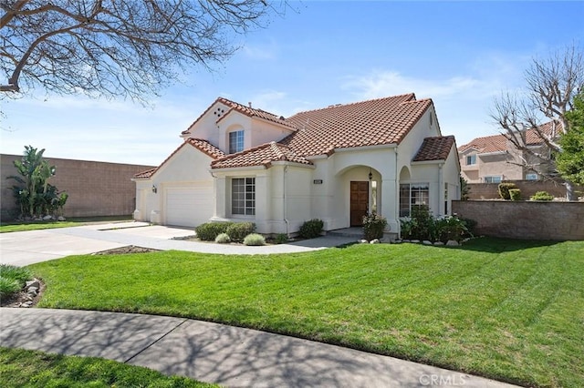 mediterranean / spanish home with a garage, a tile roof, concrete driveway, stucco siding, and a front yard