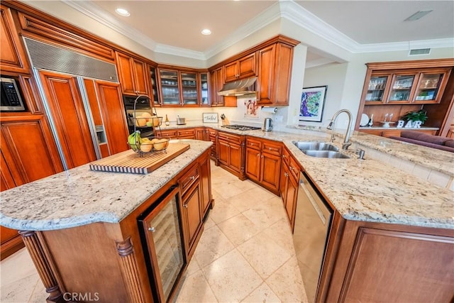 kitchen with a sink, under cabinet range hood, stainless steel appliances, wine cooler, and a peninsula