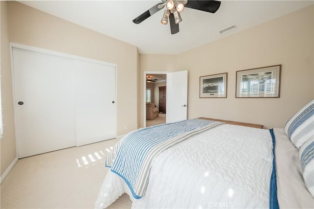 bedroom with carpet flooring, visible vents, a closet, and ceiling fan