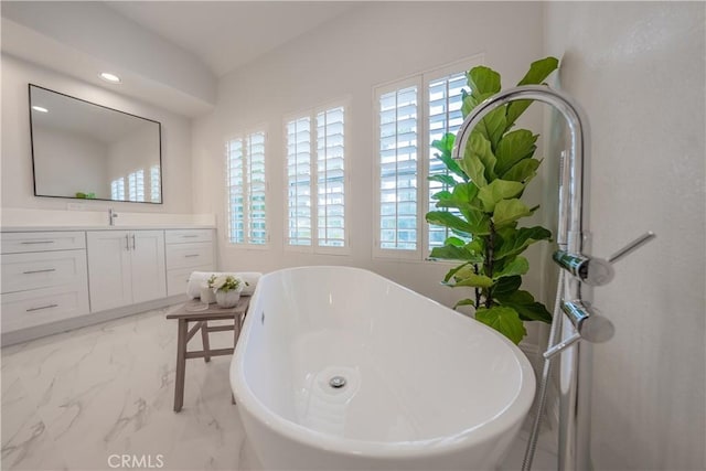 bathroom with vanity, a soaking tub, and marble finish floor