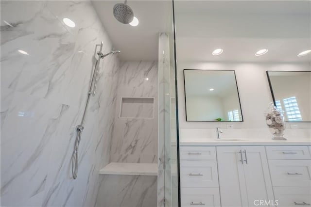 full bath with vanity, recessed lighting, and a marble finish shower