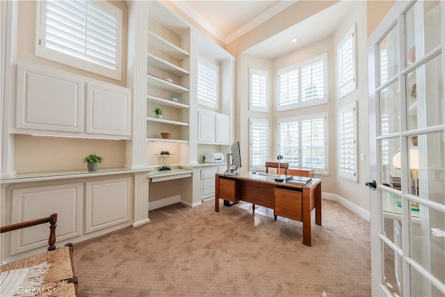 office featuring baseboards, a high ceiling, ornamental molding, french doors, and light carpet