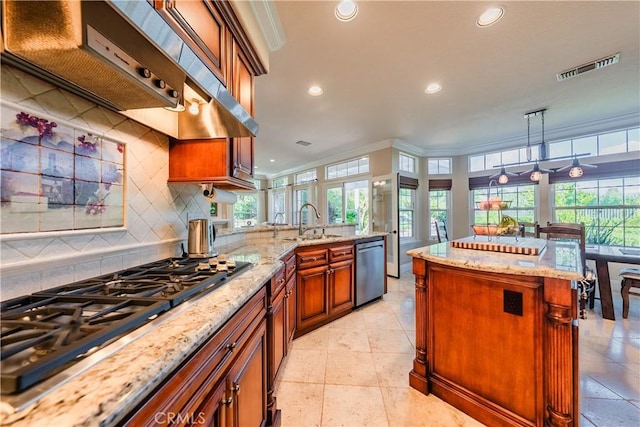 kitchen with visible vents, decorative backsplash, brown cabinets, appliances with stainless steel finishes, and a sink