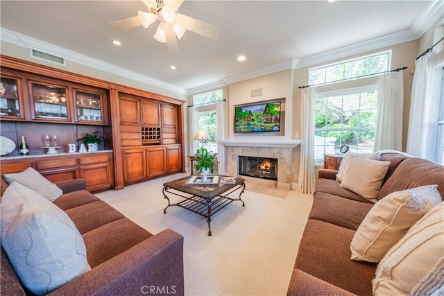 living area with visible vents, light carpet, a high end fireplace, recessed lighting, and crown molding