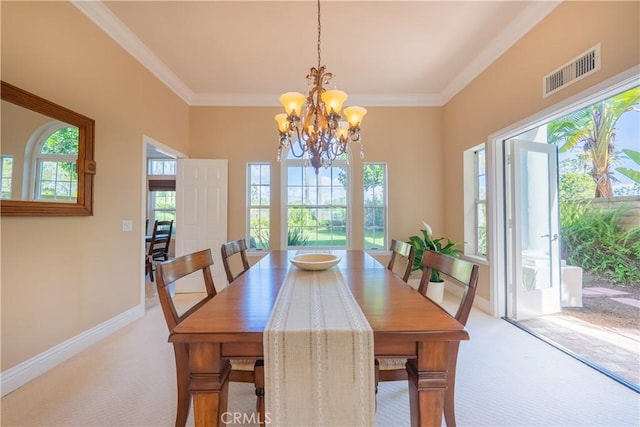 carpeted dining area featuring an inviting chandelier, baseboards, visible vents, and ornamental molding