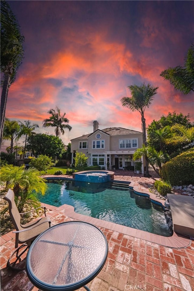 view of swimming pool with a pool with connected hot tub and a patio area