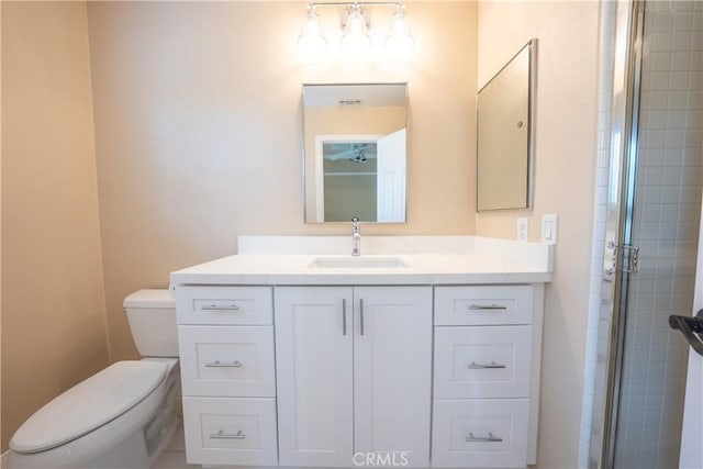 bathroom featuring vanity, toilet, and tiled shower