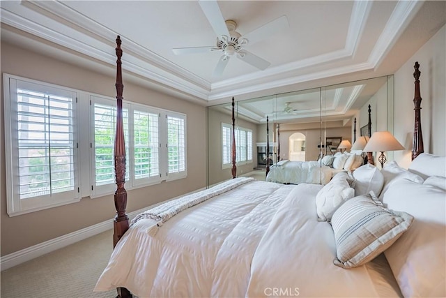 carpeted bedroom featuring crown molding, attic access, a raised ceiling, and baseboards