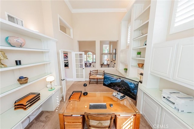 office featuring visible vents, light carpet, french doors, a high ceiling, and crown molding