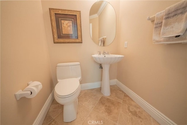 half bathroom featuring toilet and baseboards